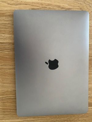 an apple laptop sitting on top of a wooden table