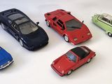 plusieurs petites voitures sont alignées sur une surface blanche