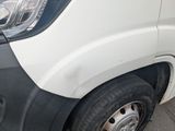 a close up of a white van parked on the side of the road