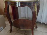 une petite table avec un plateau en marbre posée sur un sol carrelé
