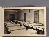 an old photo of a room filled with beds and a door