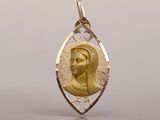 an image of a gold pendant with a woman ' s face in the center