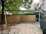 a small patio with a wooden fence and a potted planter