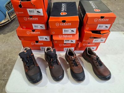 Plusieurs paires de chaussures sont alignées sur une table devant des cartons.