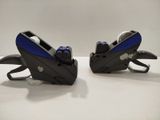 two black and blue staplers on a white table