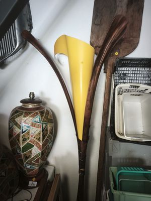 a vase and a paddle on a shelf next to a wall