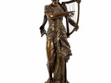 a bronze statue of a woman holding a harp