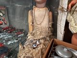 une poupée dans une vitrine, à côté d'autres poupées