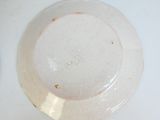 une assiette blanche à bord brun posée sur une table blanche