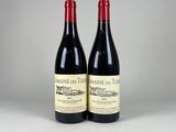 deux bouteilles de vin rouge posées l'une à côté de l'autre sur une table