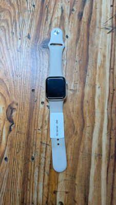 une Apple Watch blanche posée sur une table en bois