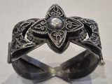 silver ring with a pearl in the middle of it on a white surface