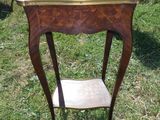 une petite table avec une étagère posée dessus, dans l'herbe