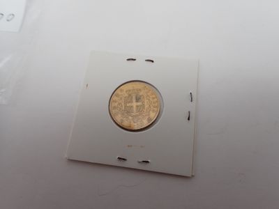 une pièce d'or posée sur un morceau de papier