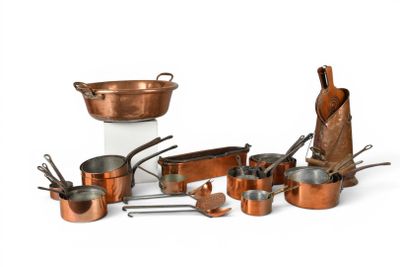a lot of copper pots and pans on the table