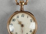 une montre de poche en or à laquelle est accrochée une chaîne