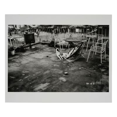 une photo en noir et blanc d'un homme assis dans un hamac