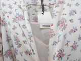 a white shirt with a floral pattern and a tag on it