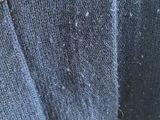 a close up of a blue sweater with a hole in it