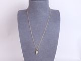 a silver necklace with a gold chain on a mannequin neck