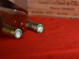 two bottles of wine sitting on a red table cloth