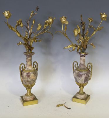une paire de vases anciens en laiton et marbre, contenant des fleurs