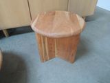 a wooden stool sitting on the floor next to a cabinet