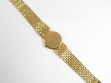 a close up of a gold watch on a white surface