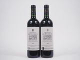 deux bouteilles de vin rouge posées l'une à côté de l'autre sur une surface blanche