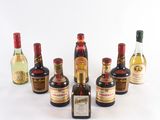 plusieurs bouteilles d'alcool sont alignées sur une surface blanche