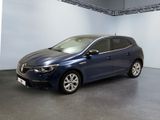 La voiture bleue est garée dans une grande pièce aux murs blancs.