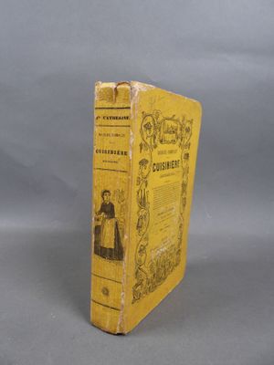 an old book sitting on top of a table on a gray surface