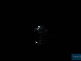 a close up of a diamond on a black surface in the dark