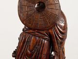 an image of a wooden statue of a person holding a fan