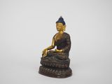 a gold statue of a buddha sitting on top of a rock