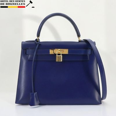 un sac à main bleu muni d'un fermoir doré sur la poignée