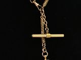 un collier composé d'une chaîne en or et d'un pendentif en verre rose