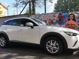 the white mazda cx - hr is parked in front of a graffiti covered wall