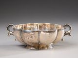 an antique silver bowl with handles and handles on a table