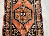 an antique persian rug with a geometric design and fringe fringes