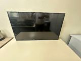 une télévision à écran plat posée sur une table blanche