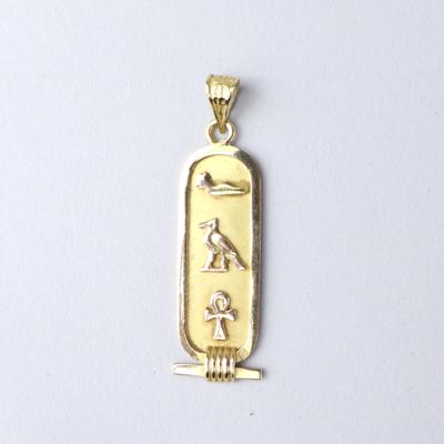 an image of a gold pendant with an egyptian symbol on it