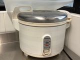 a white rice cooker sitting on a counter in a kitchen