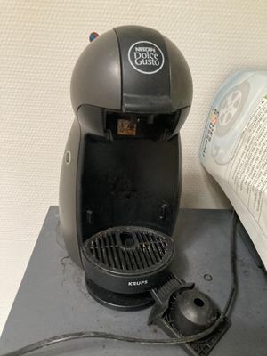 une cafetière posée sur une table à côté d'un livre