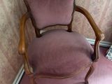 a pink chair sitting in a corner of a room