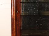 a wooden cabinet with a glass door in a room