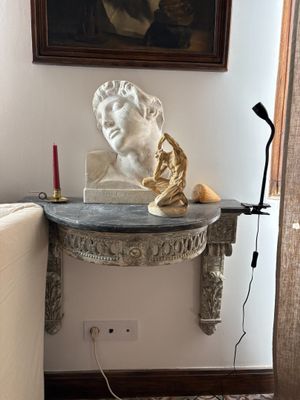 a table with a statue and a lamp on it