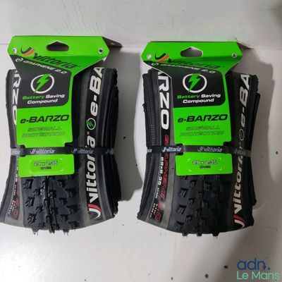 deux pneus de vélo noirs et verts sur une surface blanche