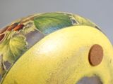 un gros plan d'un vase jaune orné d'un motif floral