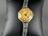 a close up of a watch on a pillow on a pillow